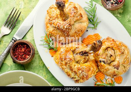 Hähnchenschenkel in Blätterteig. Hühnerbein in Blätterteig gebackenes Huhn auf dem Tisch. Stockfoto