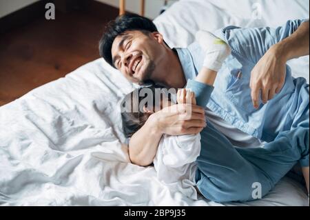 Vater und Tochter spielen im Bett Stockfoto