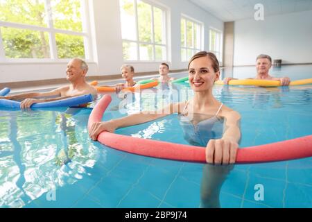 Patienten während der Remobilisierung in einem Gesundheitszentrum, die Aquarien im Wasser eines Pools machen Stockfoto