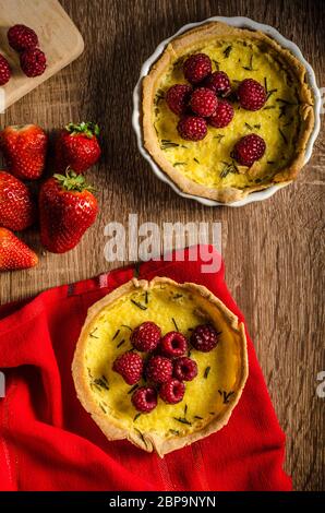 Zitronentorte mit Rosmarin und Beeren, gefüllt mit Sahne garniert Beeren Stockfoto