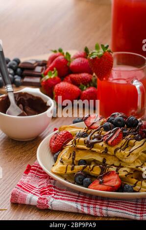 Belgische Waffeln mit Heidelbeeren, Erdbeeren mit Schokolade überzogen Stockfoto