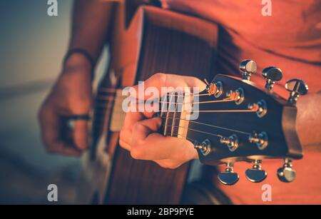 Nahaufnahme des kaukasischen männlichen Rock-Musiker spielt akustische Gitarre im Studio. Stockfoto