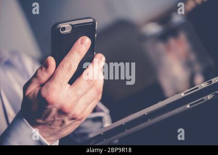 Nahaufnahme Der Hand Des Kaukasischen Männlichen In Anzug Und Holding Handy Gekleidet. Stockfoto
