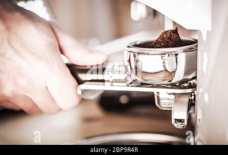 Nahaufnahme Der Männlichen Hand In Der Nähe Von Kaffeemaschine Kaffeemühle Bohnen Und Gießen Kaffee In Halter. Stockfoto