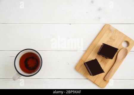 Brownie Kuchen auf einem Bambus tablett mit cuo von Tee auf einem weißen Holz- Hintergrund mit Platz für textt. top View Stockfoto