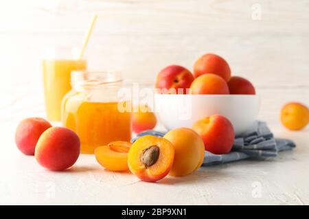 Komposition mit Aprikosen, Saft und Marmelade auf weißem Tisch Stockfoto