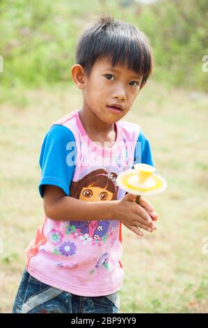 Ein junger kambodschanischer Junge spinnt den Kern einer Lotusblume, nachdem er die Blütenblätter entfernt hat, Zentralkambodschan, Südostasien Stockfoto