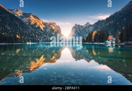 See im Nebel mit Spiegelung der Berge bei Sonnenaufgang im Herbst Stockfoto