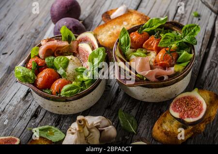 Herby Salat, frische Feigen, gebackene Tomaten, Basilikum und frisch gerösteten Knoblauch Toast Stockfoto