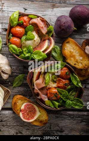 Herby Salat, frische Feigen, gebackene Tomaten, Basilikum und frisch gerösteten Knoblauch Toast Stockfoto