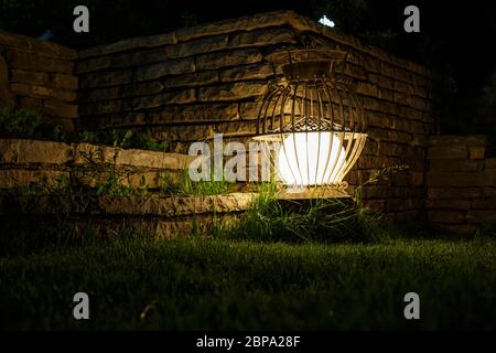 Eine alte Gartenlaterne leuchtet in der Nacht. Selektiver Fokus Stockfoto