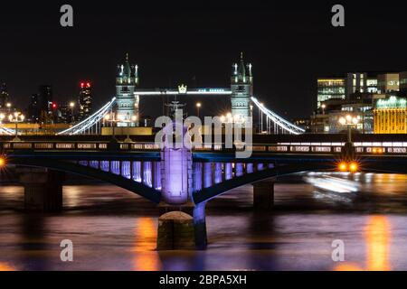 Southwark Bridge bei Nacht von der Millennium Bridge, mit Tower Bridge im Hintergrund. Beleuchtetes Flussprojekt Stockfoto