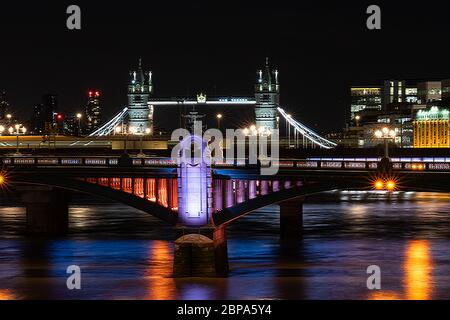 Southwark Bridge bei Nacht von der Millennium Bridge, mit Tower Bridge im Hintergrund. Beleuchtetes Flussprojekt Stockfoto