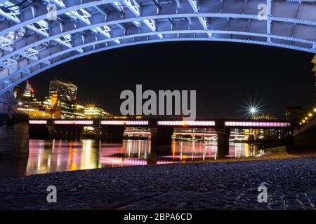 Southwark Bridge bei Nacht von unten zeigt neue Beleuchtung, alte Pflasterung und Cannon Street Bridge im Hintergrund. Stockfoto