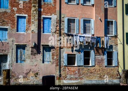 Washed Kleidung hängen vor den Fenstern in der Straße von Chioggia, in der Nähe von Venedig in Italien. Stockfoto