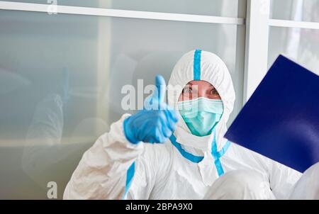 Containment Scout mit Schutzkleidung hält Daumen nach oben während Coronavirus Pandemie Stockfoto