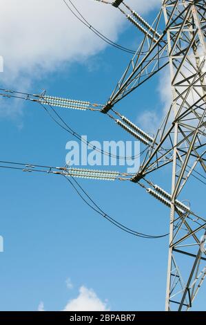 Rund um Großbritannien - Strom Pylons gegen einen blauen Himmel mit weißen flauschigen Wolken Stockfoto