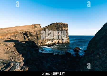 Herrlicher Sonnenuntergang an der beliebten Touristenattraktion Valahnukamol Bucht im Süden Islands. Klippen befinden sich auf der Halbinsel Reykjanes und sind leicht zu erreichen Stockfoto