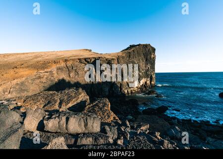 Herrlicher Sonnenuntergang an der beliebten Touristenattraktion Valahnukamol Bucht im Süden Islands. Klippen befinden sich auf der Halbinsel Reykjanes und sind leicht zu erreichen Stockfoto