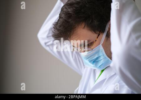 Porträt des schönen jungen Arztes, der eine medizinische Maske trägt Stockfoto