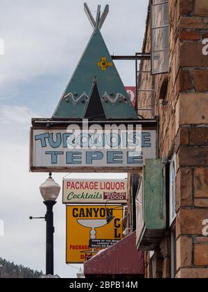 Tagsüber hängen Neonschilder an einer Gebäudewand entlang der Route 66 in Williams, AZ. Stockfoto