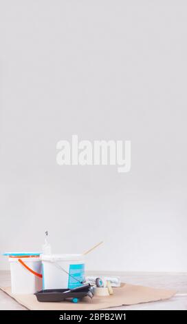 Zwei Farbeimer und Malzubehör sind bereit für die Arbeit auf Karton Schreibtisch tun es sich Renovierungsbüro Stockfoto