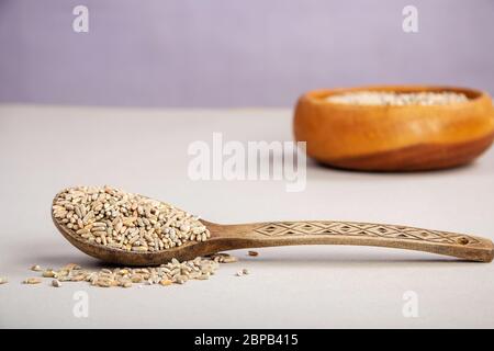 Ungeschälte RohHafer in einem Holzlöffel auf einem Holztisch Stockfoto