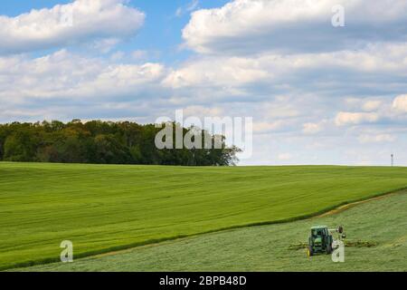 Ein Landwirt erntet mit einem Traktor ein Heufeld 12. Mai 2020 in Carroll County, Maryland. Stockfoto