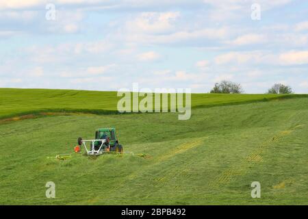 Ein Landwirt erntet mit einem Traktor ein Heufeld 12. Mai 2020 in Carroll County, Maryland. Stockfoto