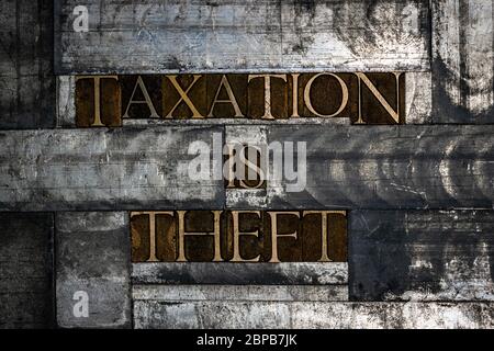 Foto von echten authentischen Schreibschrift bilden Taxation ist Diebstahl Text auf Vintage texturierten Grunge Kupfer und Silber Hintergrund Stockfoto