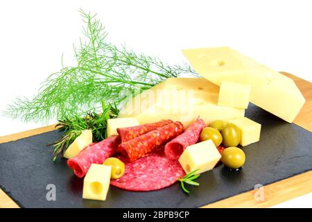 In Scheiben geschnittener emmentaler Käse, Chorizo, Salami, Oliven und Grüns auf dem Tapas-Brett. Stockfoto