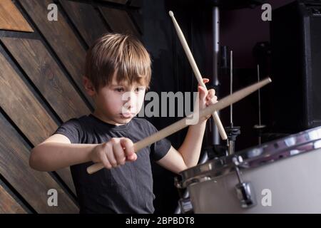 Der Junge lernt, Schlagzeug zu spielen. Das Kind hinter dem Schlagzeug. Stockfoto