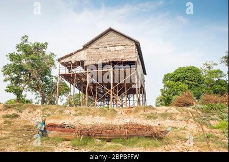 Boot auf trockenem Land und ein Haus auf Stelzen in Kampong Phluk, Provinz Siem Reap, Nord-Zentral-Kambodscha, Südostasien Stockfoto