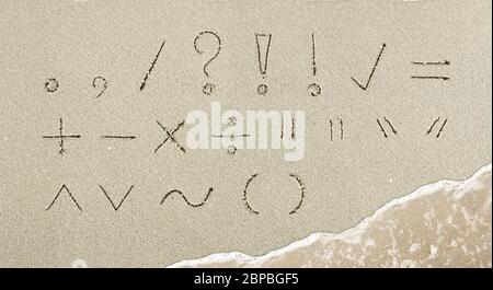 Satzzeichen handschriftlich im Sand am Strand Stockfoto