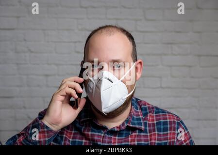 Junger Mann mit einer medizinischen Schutzmaske KN-95. Verhinderung der Ausbreitung von Virus und Epidemie, Schutz Mundfiltermaske. Krankheiten, Grippe, Luft Stockfoto