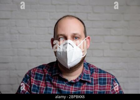 Junger Mann mit einer medizinischen Schutzmaske KN-95. Verhinderung der Ausbreitung von Virus und Epidemie, Schutz Mundfiltermaske. Krankheiten, Grippe, Luft Stockfoto