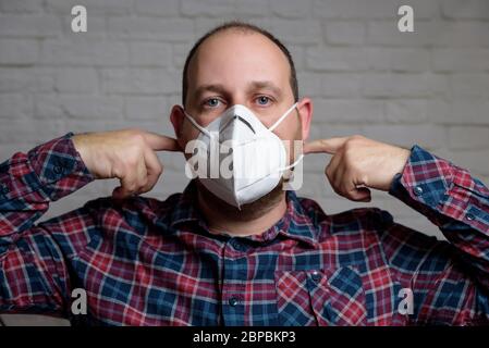 Junger Mann mit einer medizinischen Schutzmaske KN-95. Verhinderung der Ausbreitung von Virus und Epidemie, Schutz Mundfiltermaske. Krankheiten, Grippe, Luft Stockfoto