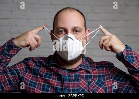 Junger Mann mit einer medizinischen Schutzmaske KN-95. Verhinderung der Ausbreitung von Virus und Epidemie, Schutz Mundfiltermaske. Krankheiten, Grippe, Luft Stockfoto