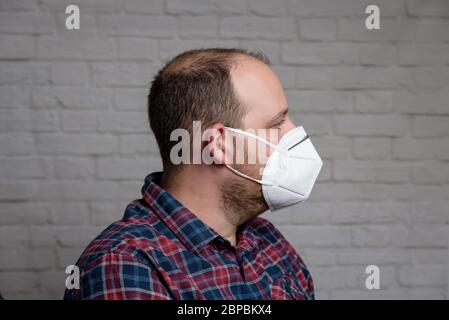 Junger Mann mit einer medizinischen Schutzmaske KN-95. Verhinderung der Ausbreitung von Virus und Epidemie, Schutz Mundfiltermaske. Krankheiten, Grippe, Luft Stockfoto