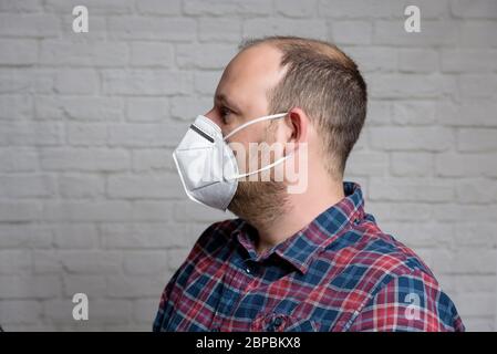 Junger Mann mit einer medizinischen Schutzmaske KN-95. Verhinderung der Ausbreitung von Virus und Epidemie, Schutz Mundfiltermaske. Krankheiten, Grippe, Luft Stockfoto