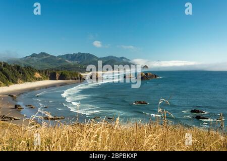 Landschaftlich schöner Blick auf Crescent und Cannon Beach mit Haystack Rock am Rande des Nebels vom Ecola State Park in Oregon aus gesehen Stockfoto