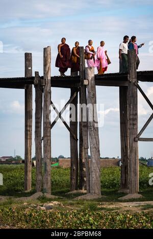 Mandalay, Myanmar - Juni 2017: Mönche überqueren die U Bein Brücke in der Dämmerung Stockfoto