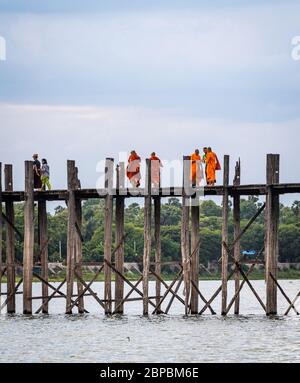 Mandalay, Myanmar - Juni 2017: Mönche überqueren die U Bein Brücke in der Dämmerung Stockfoto