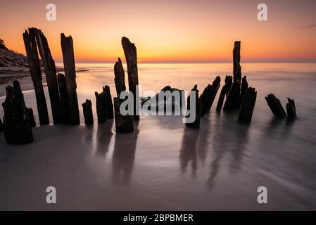 Holzpfähle auf der Ostsee während Sonnenuntergang Karwia Dorf, Polen Stockfoto