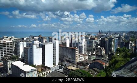 Blick hinunter auf die Stadt Salvador, Brasilien mit der Bucht im Hintergrund. Blauer Himmel und Wolken auch im Bild. Stockfoto