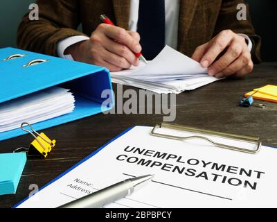 Antrag auf Arbeitslosenunterstützung und Sachbearbeiter mit Papieren. Stockfoto