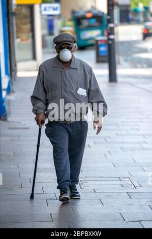 Cardiff City Centre, am 18. März 5/20 während der Covid 19 Lockdown fotografiert. Ein Mann trägt eine Maske, wenn er mit einem Stock auf der Castle Street geht. Stockfoto