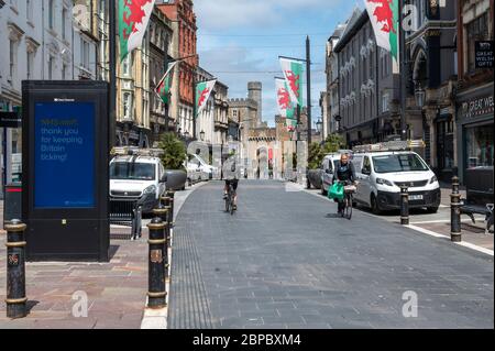 Cardiff City Centre, am 18. März 5/20 während der Covid 19 Lockdown fotografiert. Radfahrer auf der High Street vor der Kulisse des Schlosses. Stockfoto