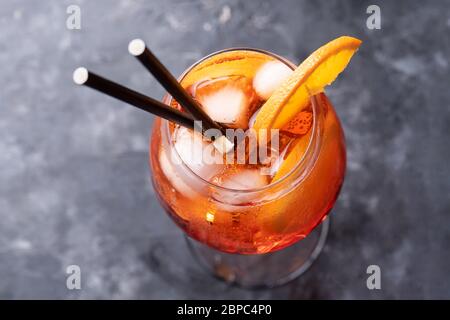 Klassischer italienischer Aperitif aperol Spritz Cocktail aus Glas mit Orangenscheibe auf dunklem Hintergrund, Draufsicht Stockfoto