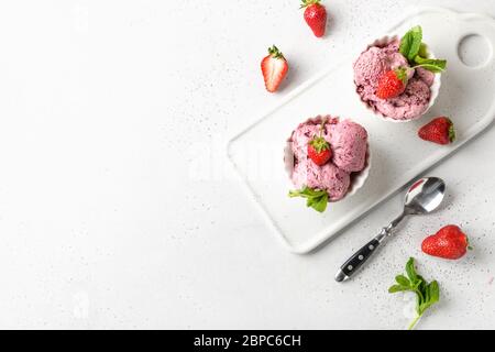 Hausgemachtes Erdbeereis in Schalen auf weißem Hintergrund. Blick von oben. Platz für Text. Sauberes Essen. Ohne Zucker. Stockfoto